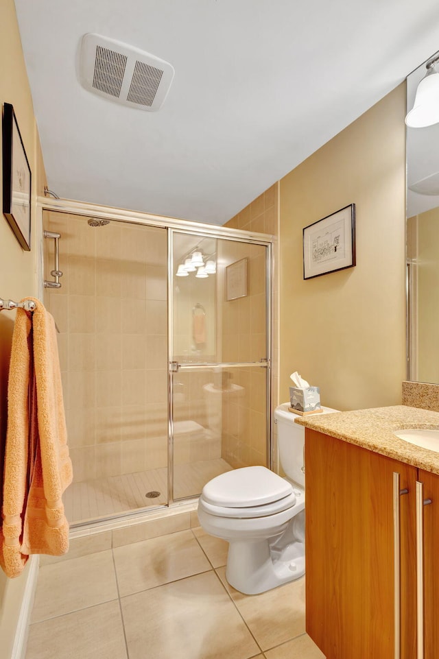 bathroom with tile patterned flooring, an enclosed shower, vanity, and toilet