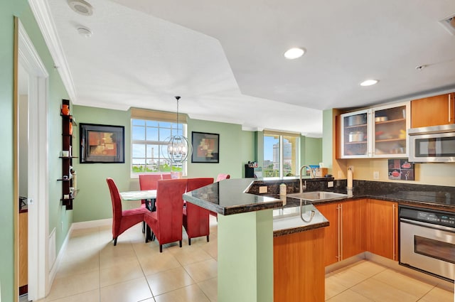 kitchen featuring stainless steel appliances, kitchen peninsula, a wealth of natural light, and sink