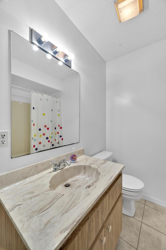 bathroom featuring vanity, toilet, a textured ceiling, and tile patterned flooring