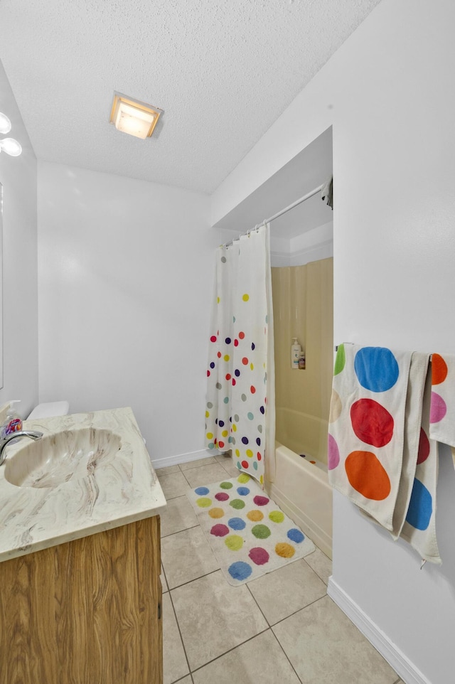 bathroom with vanity, shower / bath combo with shower curtain, a textured ceiling, and tile patterned floors