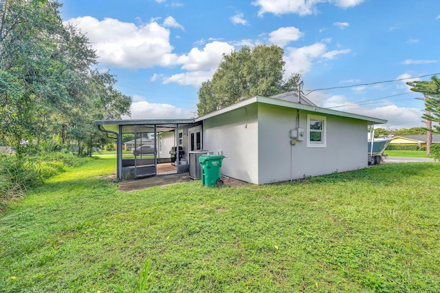 back of house featuring a yard and a sunroom