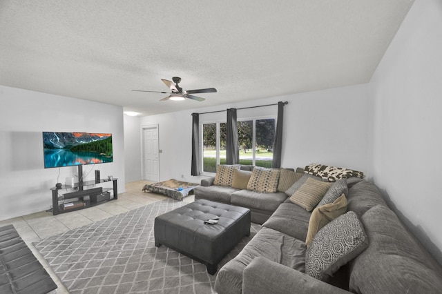 living room featuring ceiling fan, a textured ceiling, and tile patterned flooring