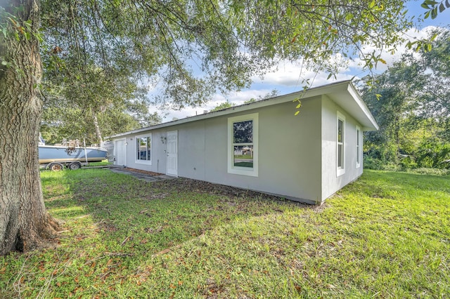 5000 Fort Pierce Blvd, Fort Pierce, FL 34951 - rear view of property with stucco siding and a yard