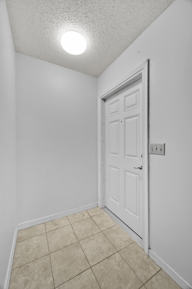 5000 Fort Pierce Blvd, Fort Pierce, FL 34951 - spare room with a textured ceiling, light tile patterned flooring, and baseboards