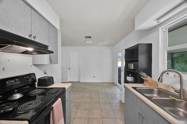 kitchen with sink, light tile patterned floors, black range with electric stovetop, and gray cabinets