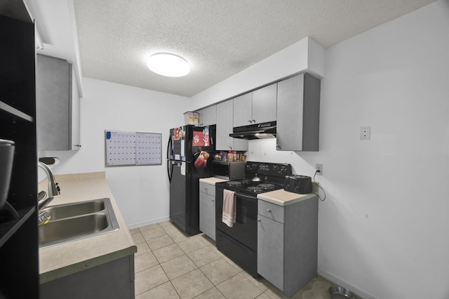 kitchen with a textured ceiling, black appliances, sink, and gray cabinetry