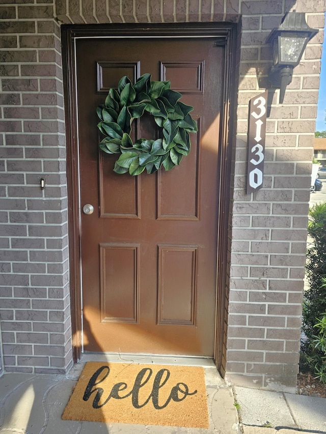 view of exterior entry with brick siding