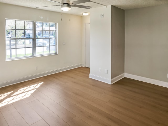 unfurnished room with ceiling fan, a textured ceiling, and light hardwood / wood-style flooring