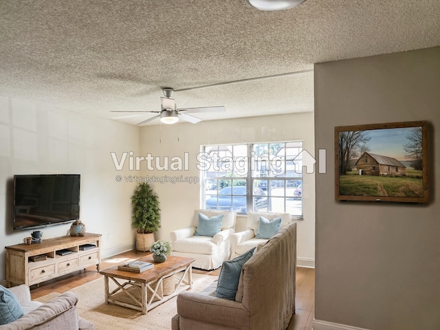 living room featuring baseboards, wood finished floors, a textured ceiling, and ceiling fan