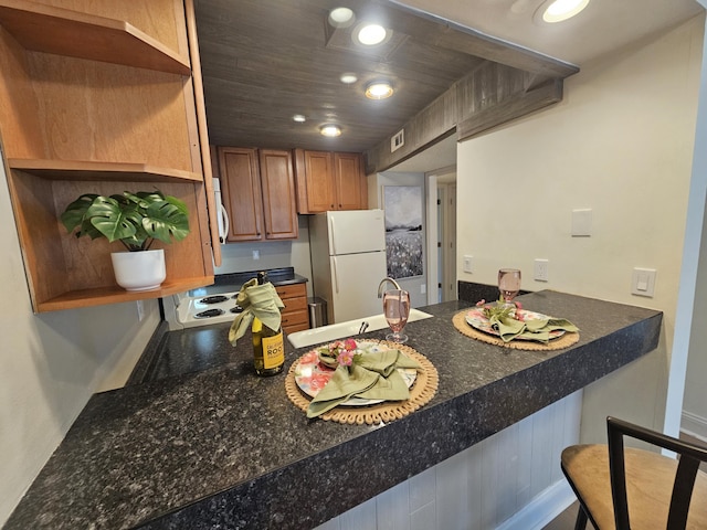 kitchen with open shelves, a sink, recessed lighting, white appliances, and a peninsula