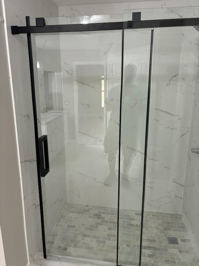 bathroom with a marble finish shower