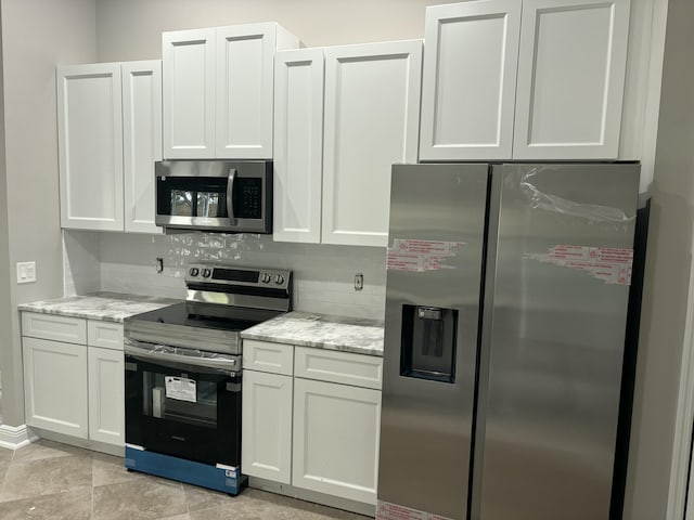 kitchen featuring white cabinetry, appliances with stainless steel finishes, and light stone counters