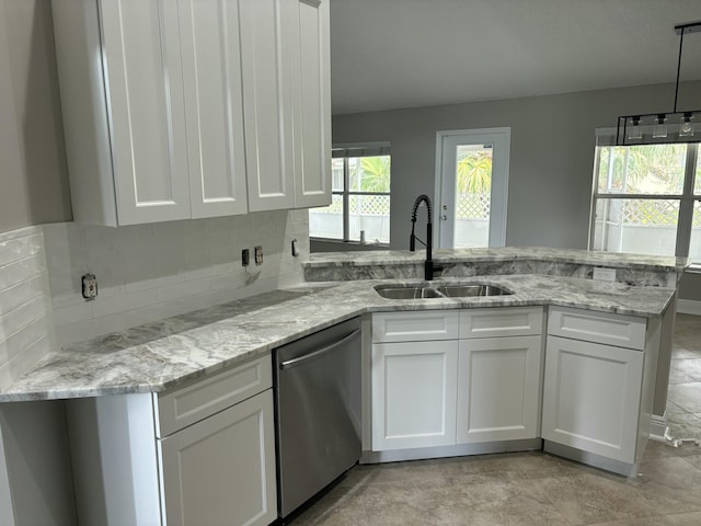 kitchen with a sink, light stone countertops, white cabinets, and stainless steel dishwasher