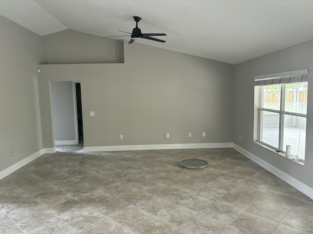 empty room with ceiling fan, baseboards, vaulted ceiling, and a textured ceiling