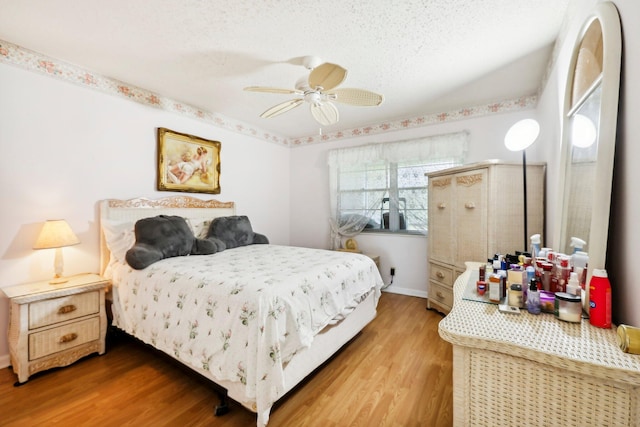 bedroom with hardwood / wood-style flooring, ceiling fan, and a textured ceiling