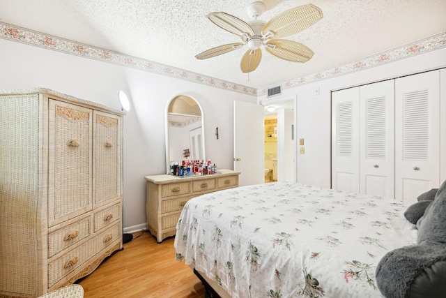 bedroom with ceiling fan, light wood-type flooring, and a textured ceiling