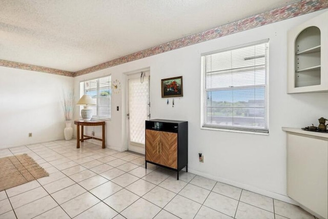 entryway featuring light tile patterned floors and a textured ceiling