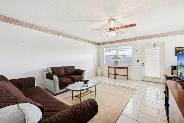 tiled living room featuring ceiling fan and a textured ceiling