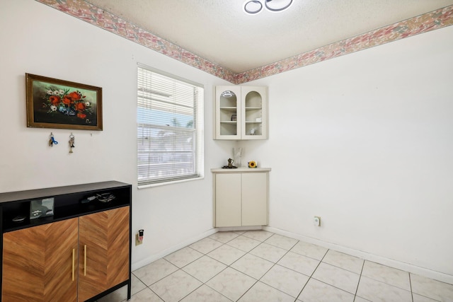 dining area featuring light tile patterned flooring and a textured ceiling