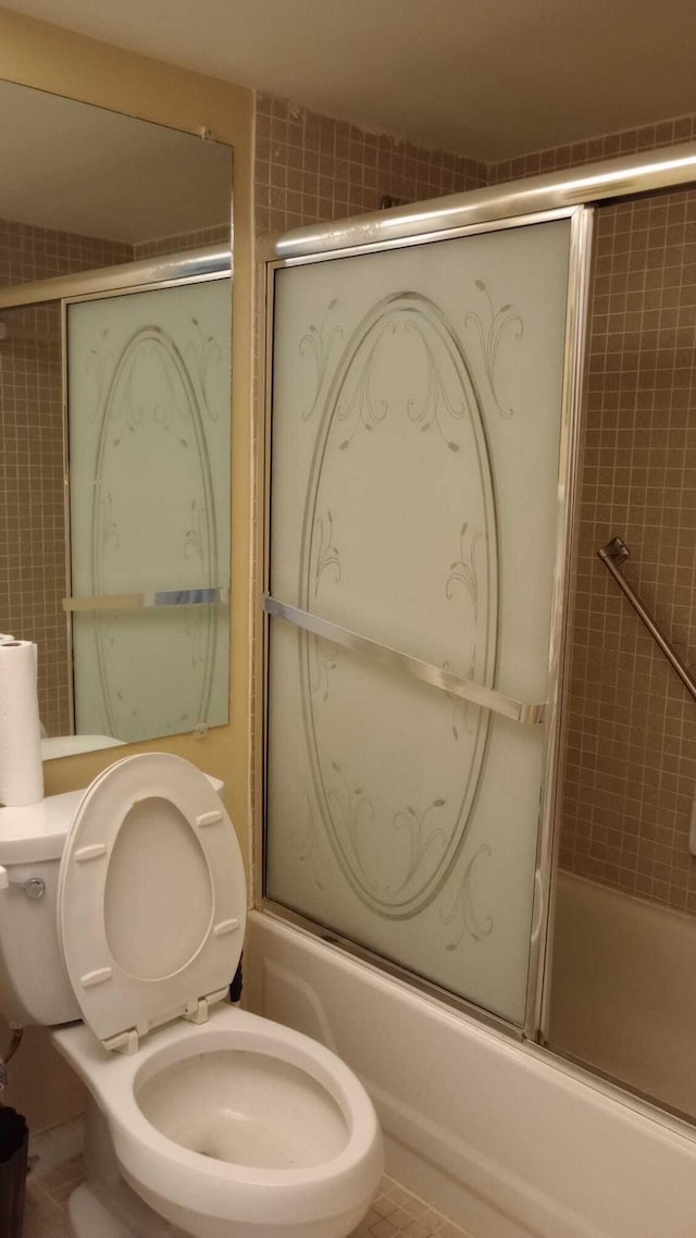 bathroom featuring toilet, tile patterned floors, and shower / bath combination with glass door