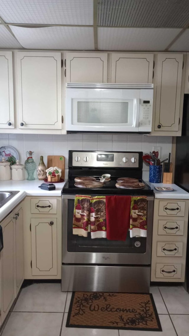 kitchen with stainless steel range with electric stovetop and light tile patterned floors