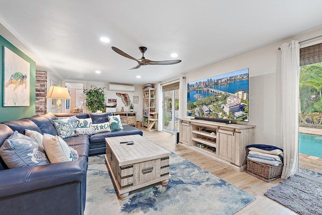 living room featuring ceiling fan, light hardwood / wood-style floors, and a wall mounted air conditioner