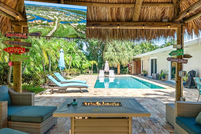 view of pool with an outdoor fire pit and a patio