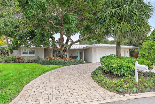 single story home featuring a front lawn and a garage