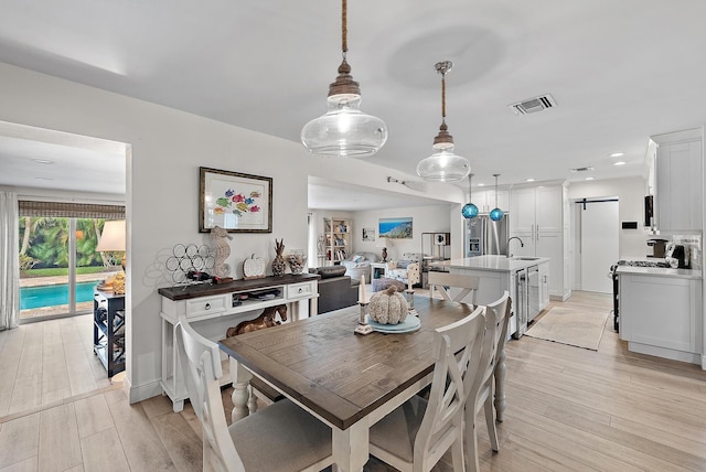 dining space with a barn door and sink