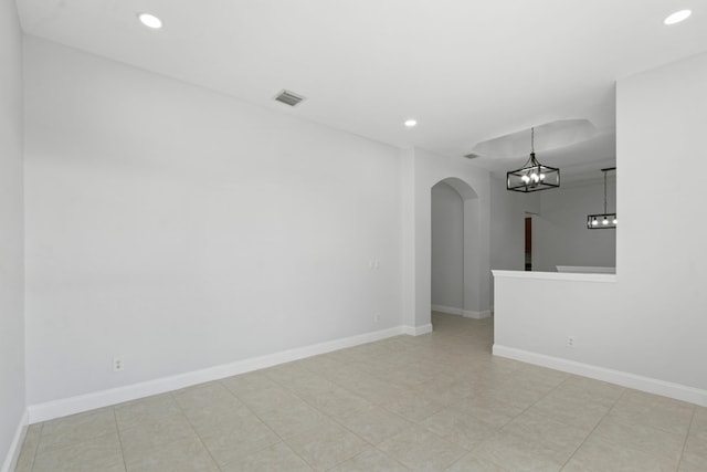 unfurnished room featuring an inviting chandelier