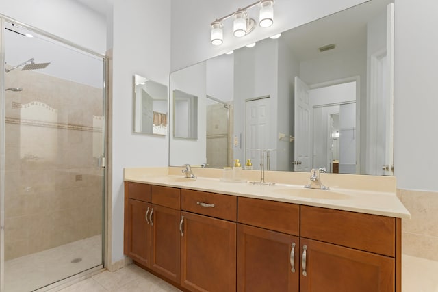 bathroom with tile patterned flooring, vanity, and a shower with door