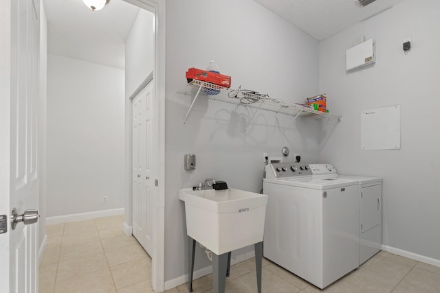 washroom featuring light tile patterned flooring, sink, and independent washer and dryer