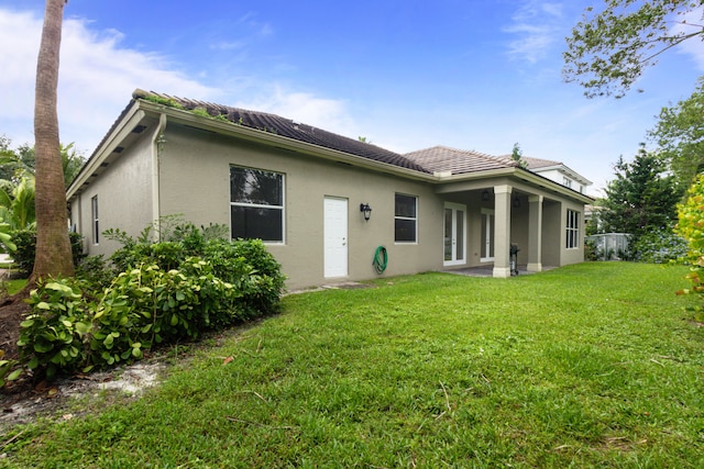 rear view of house featuring a patio and a yard