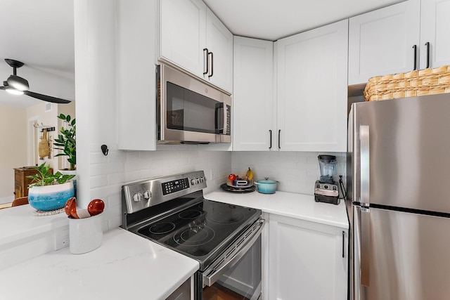 kitchen featuring light stone counters, white cabinets, decorative backsplash, appliances with stainless steel finishes, and ceiling fan