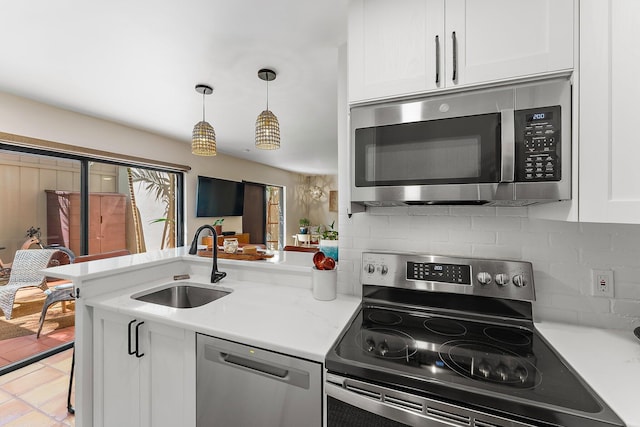 kitchen with decorative backsplash, white cabinetry, appliances with stainless steel finishes, and sink