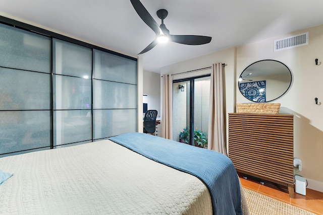 tiled bedroom featuring ceiling fan