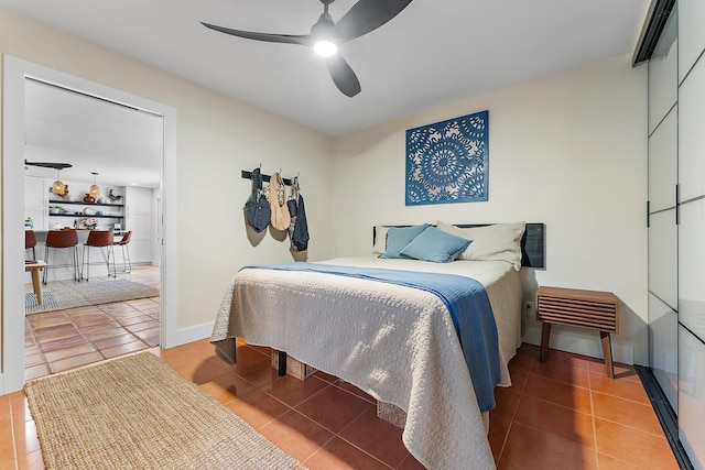 tiled bedroom featuring ceiling fan and bar area