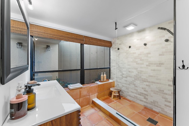 bathroom with vanity and tiled shower