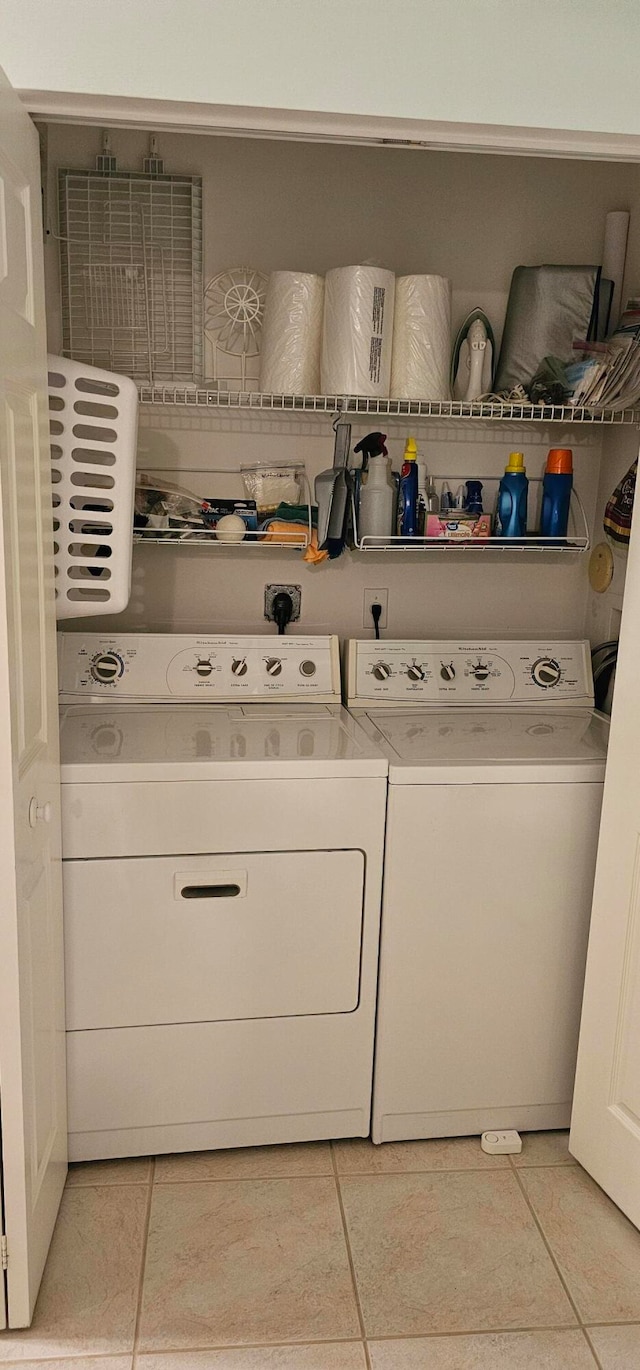 laundry area featuring washing machine and dryer and light tile patterned floors