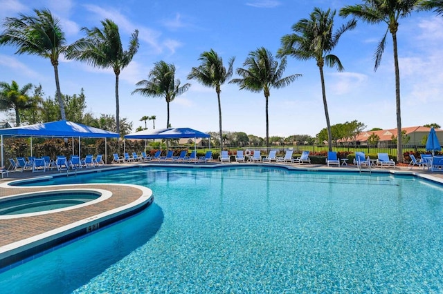 pool with a hot tub, fence, and a patio