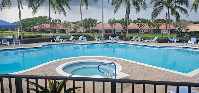 view of swimming pool featuring a hot tub and a patio