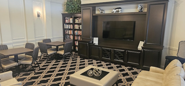 living area featuring carpet flooring and a decorative wall