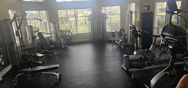 exercise room featuring a wealth of natural light and baseboards