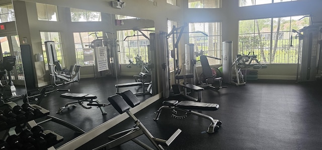workout area featuring a towering ceiling and baseboards