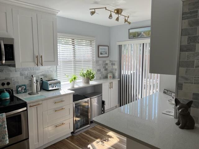 5324 Fountains Dr S, Lake Worth, FL 33467 - kitchen featuring tasteful backsplash, light countertops, white cabinets, wine cooler, and stainless steel appliances