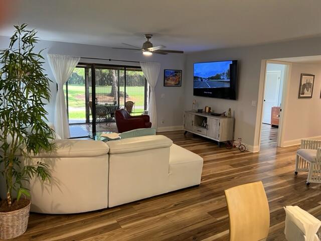 living room with dark hardwood / wood-style floors and ceiling fan