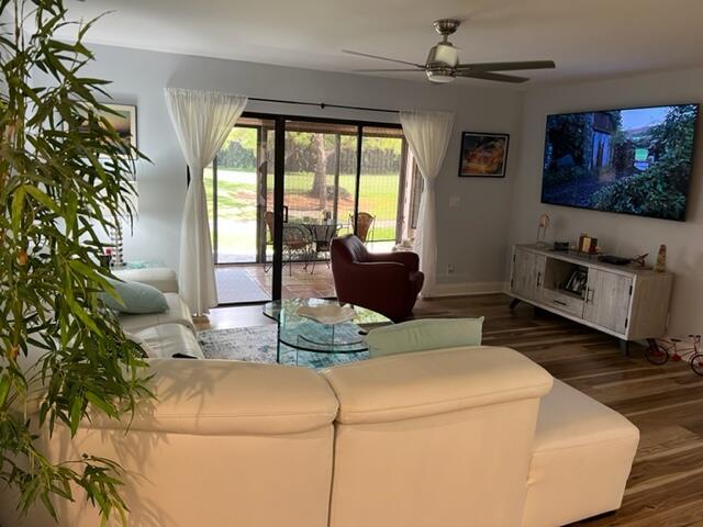 living room featuring ceiling fan and wood-type flooring