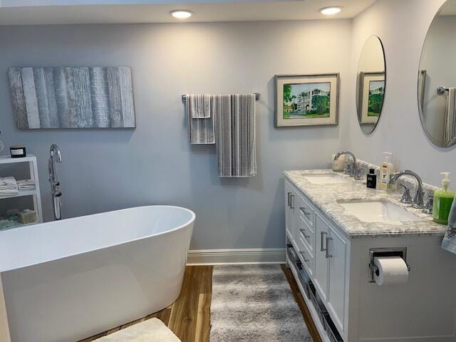 bathroom featuring hardwood / wood-style flooring, vanity, and a bathtub