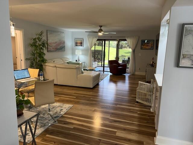 living room featuring dark hardwood / wood-style flooring and ceiling fan