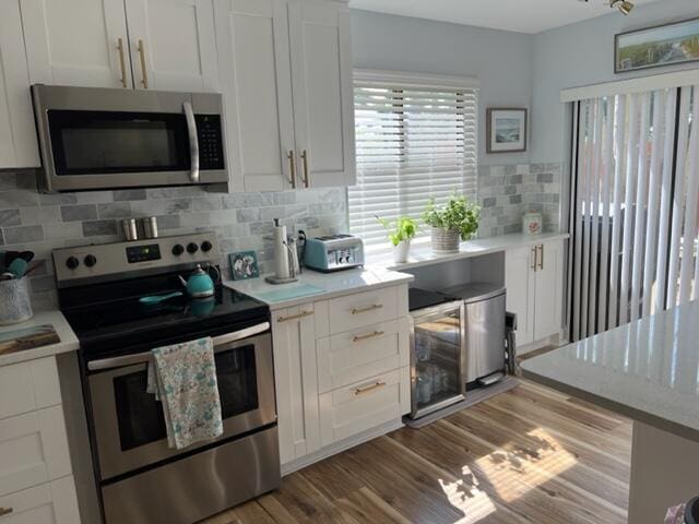 kitchen featuring backsplash, stainless steel appliances, and white cabinets